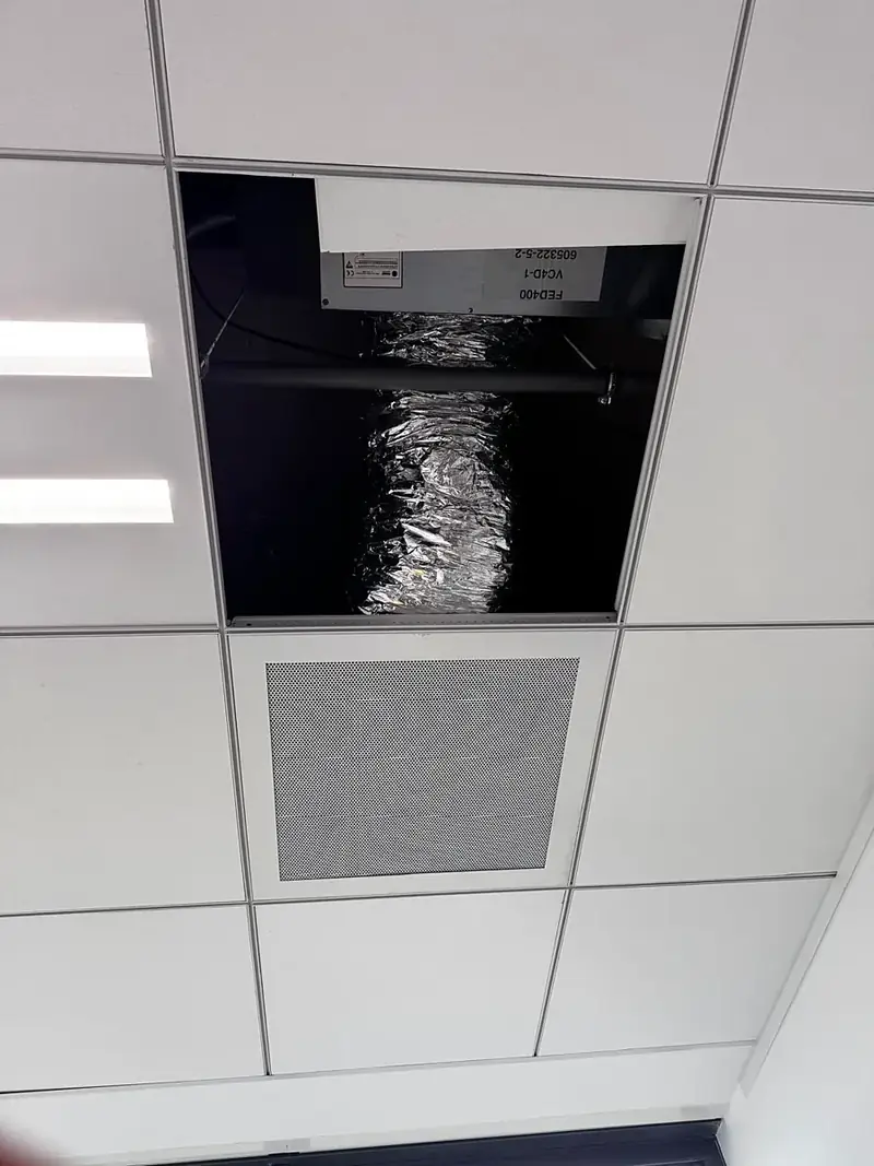 Unité gainable installée dans le faux plafond de bureaux, avec sa gaine et sa grille de soufflage