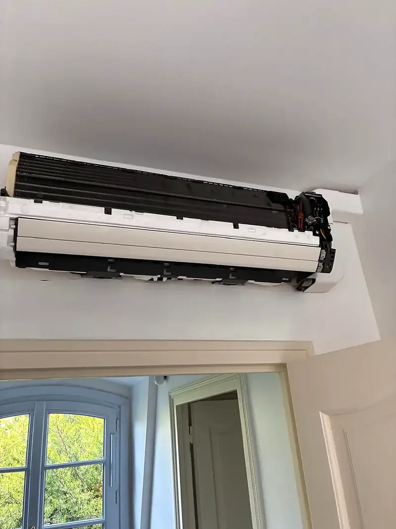 Climatiseur mural ouvert pendant un entretien, unité intérieure en cours de nettoyage