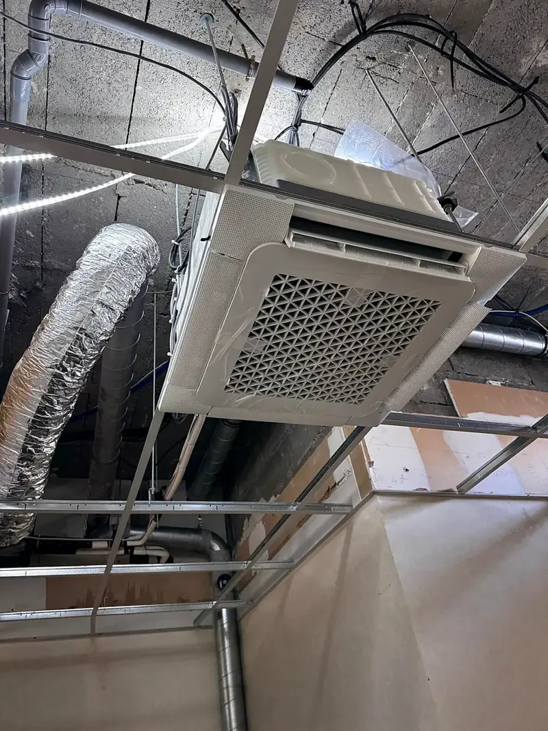 Cassette 4 voies en cours de pose dans le faux plafond de bureaux