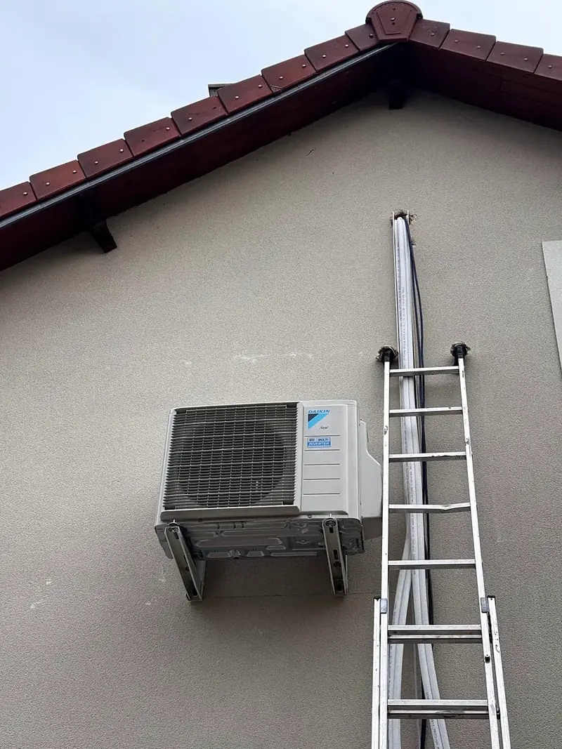 Groupe extérieur Daikin multi-split posé sur le pignon d’une maison, liaisons frigorifiques le long de la façade